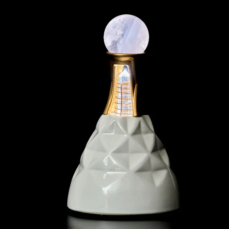 Living Crystal with ceramic base, gilded neck, illuminated Vogel-inspired crystal, and a pale quartz sphere